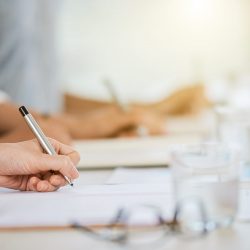 Hand of business lady signing agreement at meeting