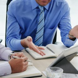 Cropped image of business people dicussing information on digital tablet